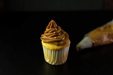 cupcakes or cupcakes with dulce de leche pastry cake and sprinkles on a black background