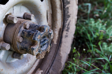 Closeup photo of the SUV front wheel,  covered in mud and clay.