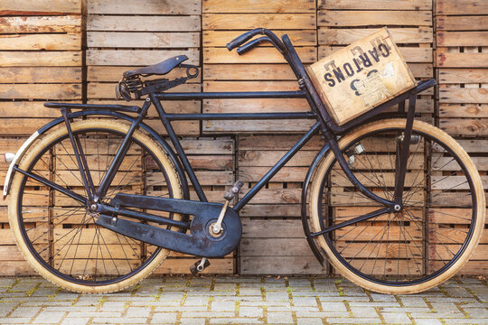 Vintage black cargo transport bicycle in front of old wooden crates