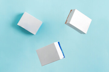 Flying handcraft mock-up paper boxes for packaging natural products and goods above light blue background. Top view.