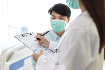 Medicine and health care concept.  Asian  woman doctor is taking care patient in hospital.doctor or nurse wear protection mask checking and takecare infection people from covid-19 .