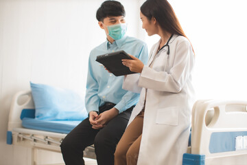 Fototapeta premium Medicine and health care concept. Asian woman doctor is taking care patient in hospital.doctor or nurse wear protection mask checking and takecare infection people from covid-19 .