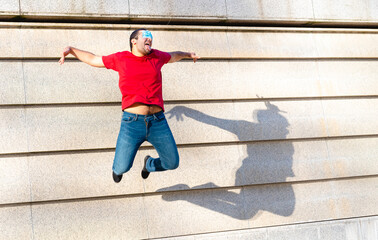 young boy of generation Y in flight during a jump, creative and inappropriate use of protective masks, a symbol of optimism and positivity for the future by the younger generations