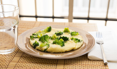 wholesome breakfast. omelet with broccoli on brown plate
