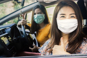 two Asian women wearing mask sitting in a car before traveling new normal lifestyle concept 