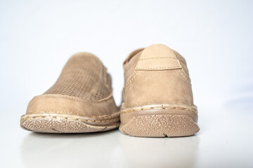 Men's beige leather shoes, models moccasins. Photographed close-up on a light background.