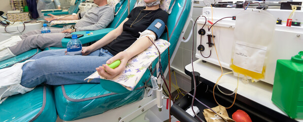 a donor in an armchair donating blood at hemotransfusion station