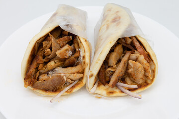 Two Wrapped Pork Gyros on a White Plate with a White Background