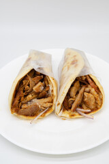 Two Wrapped Pork Gyros on a White Plate with a White Background