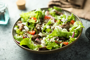 Green salad with beef steak and fresh cheese