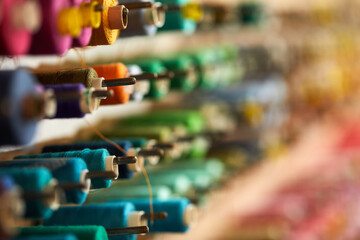 Colorful cotton thread rolls for sewing machine in store. thread spools for garment industry