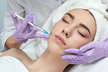 Obraz na płótnie Canvas beautiful woman is getting beauty injections on the lips. beauty treatment and cosmetology