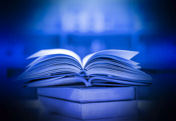 The blurred book that is bewitched with magic, the magic light in the dark, with the bright light shining down as the power to search for knowledge. For research and use as a blurred background