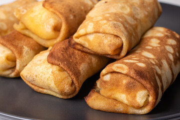 Pancakes stuffed on a black background. Homemade pastries, gluten-free and wheat flour.