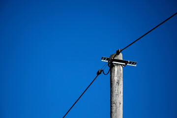old wooden electric pole against blue sky