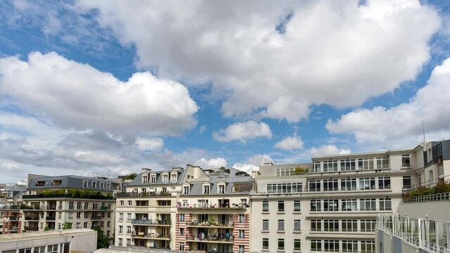 4K Timelapse view of moving clouds on a cloudy day above typical buildings in Paris, FRANCE.