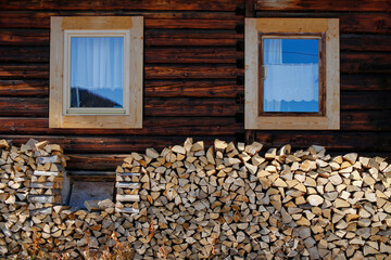 stacked firewood in front of wooden cottage