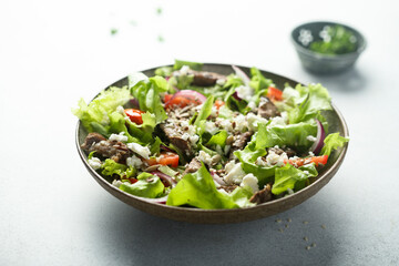 Green salad with beef steak and fresh cheese