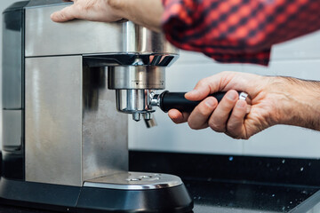 Detail of man's hands preparing an espresso