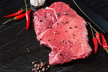 Raw beaf meat. Fresh steaks on slate board on black background. Top view