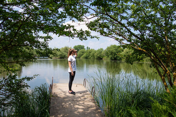 Fototapeta na wymiar Pretty Teen Girl resting near a pond in the park