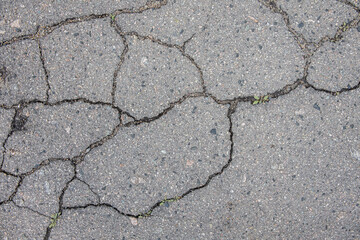 Obraz premium Background and texture of pavement with cracks close up. A symbol of trouble and problems in the relationships