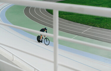 Cyclist and track bike trains on an empty velodrome. Cycling as a hobby. Cycling training of the velodrome. Top view, background