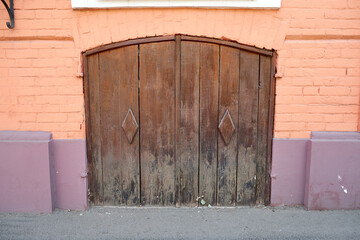 Wooden locked gate in an orange brick wall