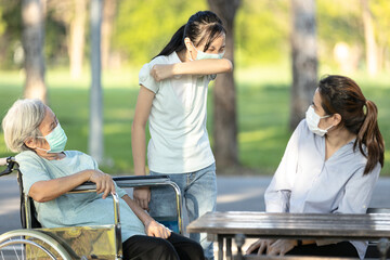 Sick asian child girl has flu wearing protective face mask,sneezing,coughing into her arm or elbow to prevent spread Covid-19,Coronavirus disease,ill female people covering nose and mouth while sneeze