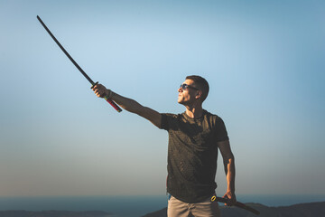 Young man with a katana in the mountain.