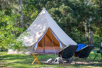 Wall murals Camping Glamping camping teepee tent and chairs at the campsite