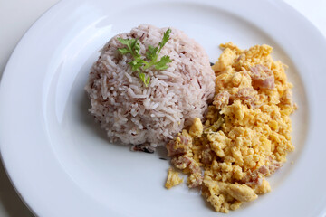 Riceberry with omelette served in a white round dish Put on the white table Ready to eat