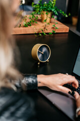 Golden Time Management clock on a desk with a woman behind a computer