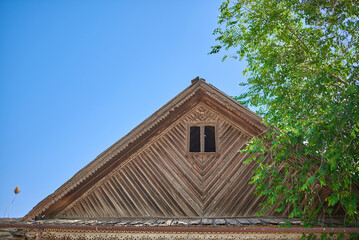 Fototapeta na wymiar Attic of an old wooden house against a blue sky