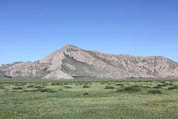 Fototapeta premium Large gray rocky mountains amid the blue sky