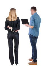 Back view of business woman and business man in suit with laptop.