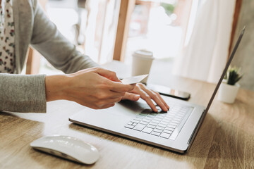 Woman using credit card on laptop for shopping online