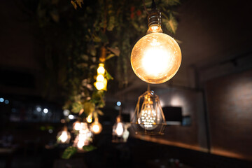 Close-up object of an Antique shiny electrical lamp that decorate in the dark room, with other many light bulbs as blurred background.