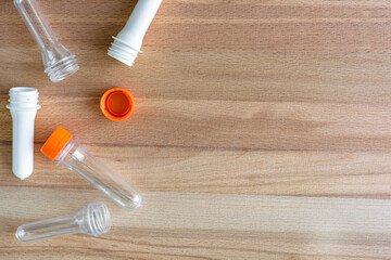 Top view of transparent preforms and white preforms and orange closure