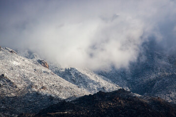 Winter mountain, snow capped and cloud covered