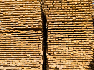 A large pile of boards sawn from trees on a sawmill for the procurement of building materials for...