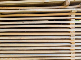 A large pile of boards sawn from trees on a sawmill for the procurement of building materials for...