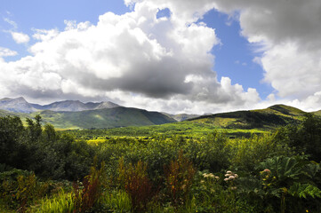 Obraz premium Magnifique vue panoramique sur les monts et les collines dans un val à l'embouchure d'un bras de mer en Irlande. Ciel orageux, verdure et clair-obscur.