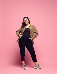 Fashionable, stylish. Young woman in casual wear on pink background. Bodypositive character, feminism, loving herself, beauty concept. Plus size businesswoman, beautiful girl. Inclusion, diversity.