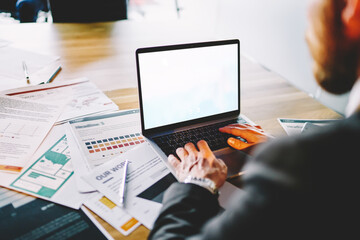 Unrecognizable businessman working with laptop on office