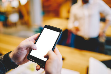 Anonymous man watching cellphone in office