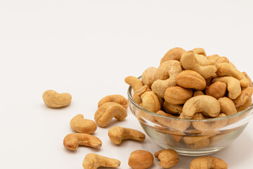 Tasty cashew nuts in the glass bowl on white background, A food that is beneficial to health Eaten as a snack is tasty and contains vitamins K, E, B6, Phosphorus, Magnesium and antioxidants.