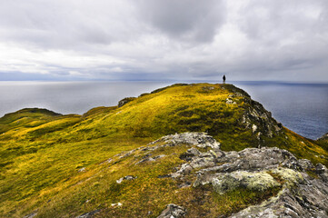Fototapeta premium Falaises couvertes de verdure et se détachant sur le gris de la mer au nord de l'Irlande.