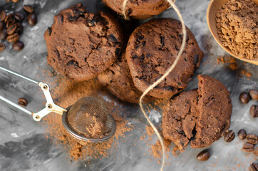 cookies with pieces of chocolate tied with a thread lie on a table sprinkled with cocoa powder
