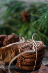 cookies with pieces of chocolate tied with a string on the background of fir branches. Christmas cookies